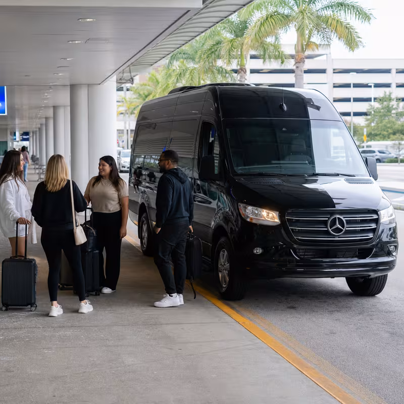 Group boarding a white charter bus for Airport Transportation transportation in Coral Springs