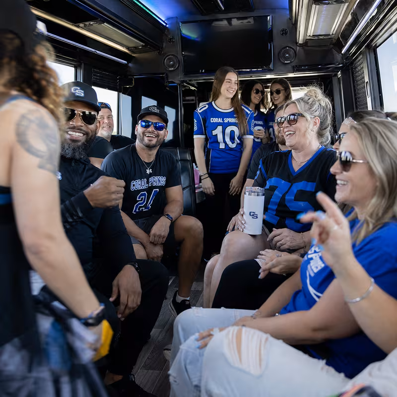 Group boarding a white charter bus for Sporting Event Transportation transportation in Coral Springs